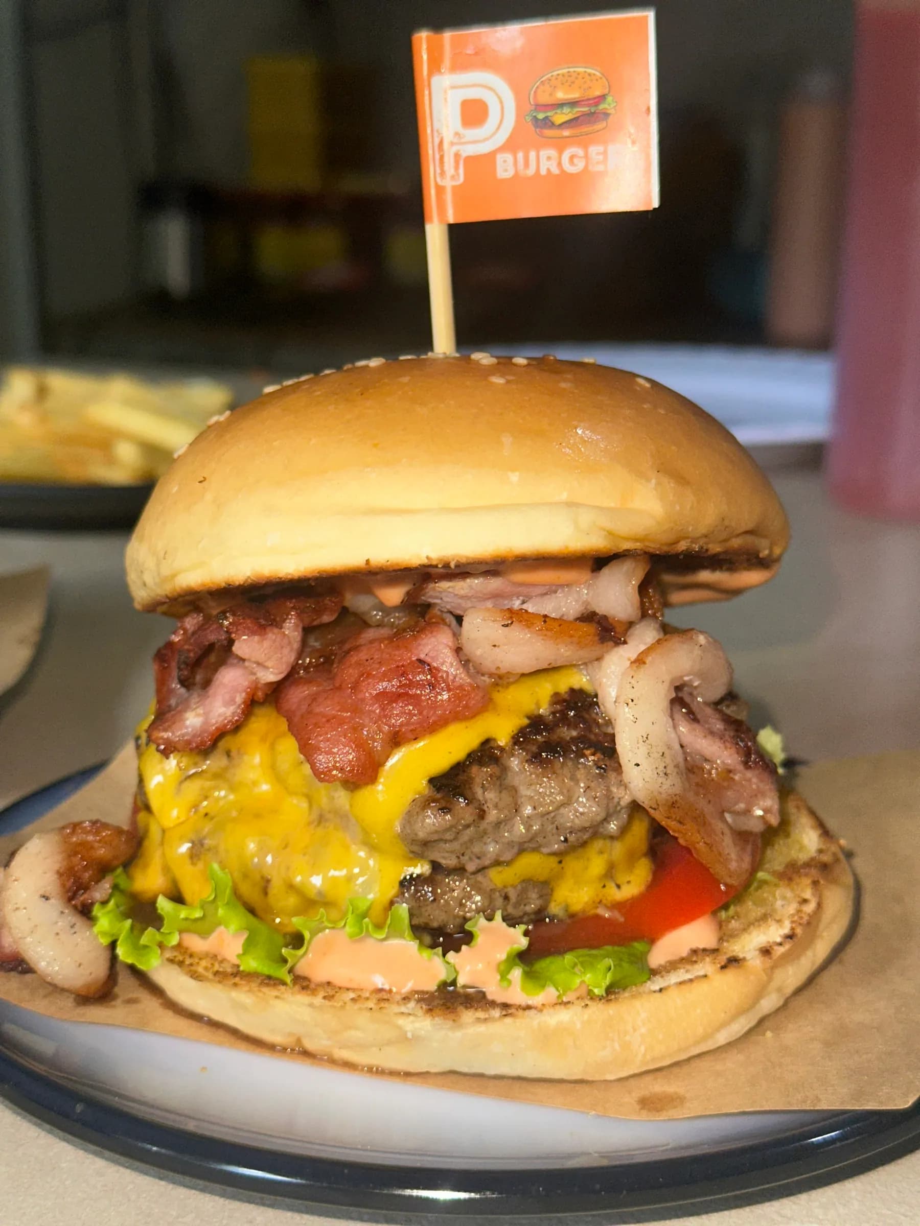 P Burger with an orange P flag, stacked with bacon and cheddar